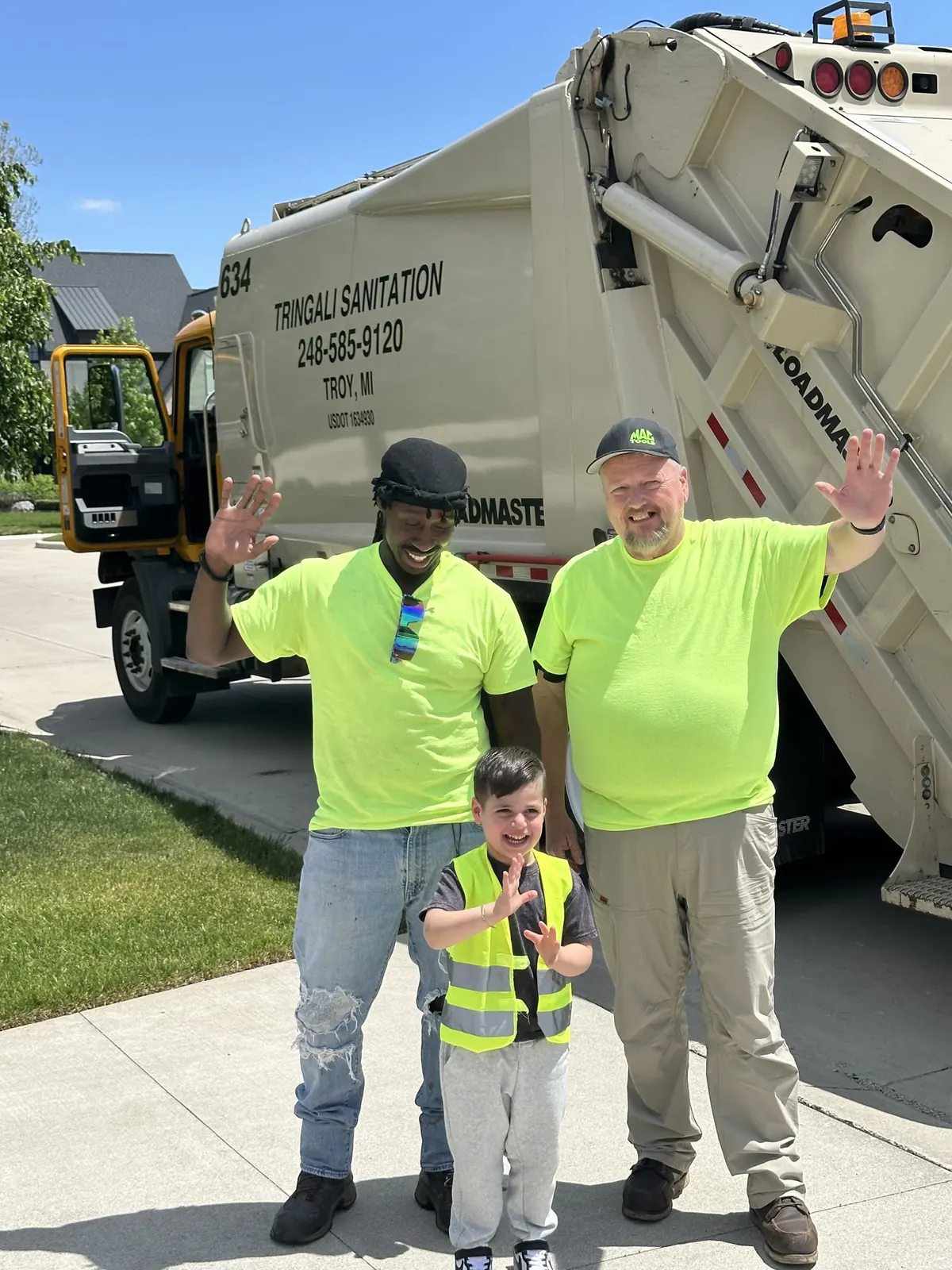 Tringali Sanitation crew with a community member in front of a branded truck